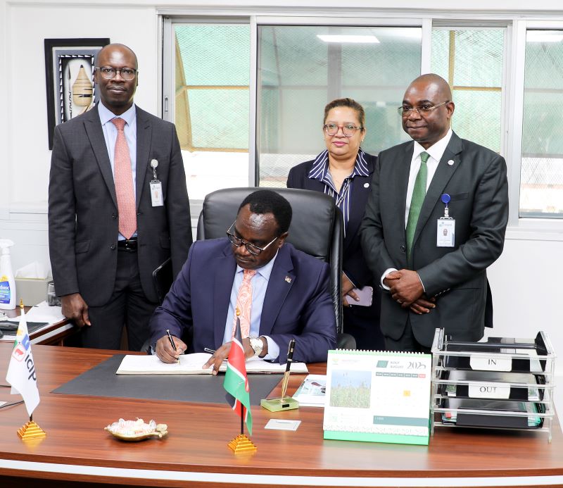 Kenya’s Cabinet Secretary for Education Hon Julius Migos Ogamba signing the visitors book when he visited icipe. He is flanked by the Director General Dr Abdou Tenkouano (Right), The Director, Human Resources & Protocol, Mrs Veronica Waiyaki (Centre behind the Minister) and Dr Julius Ecuru, The RCU Manager (Left)